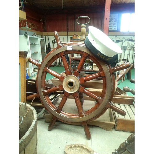 7614 - A mahogany ships wheel and HMS Neptune Sailors hat