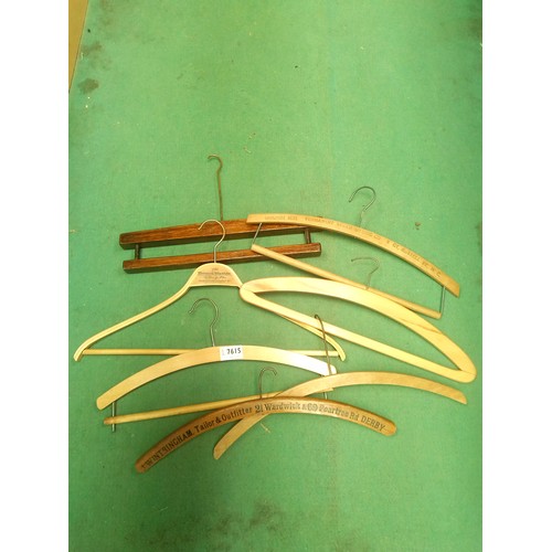 7615 - Seven Vintage wooden coat hangers some named  including Wintringham Tailor