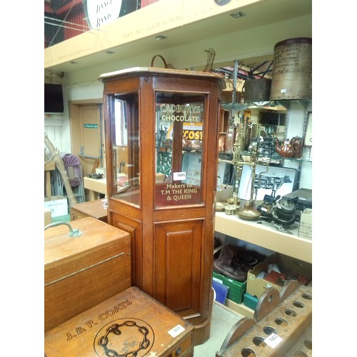 7605 - An oak hexagonal glazed cabinet with later painted Cadburys Cocoa lettering to glass, 86cm tall