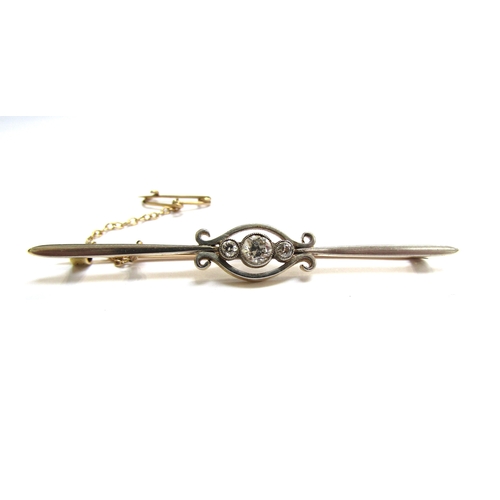 9187 - An early 20th Century gold and platinum bar brooch, centred by three graduated diamonds, unmarked, 6... 