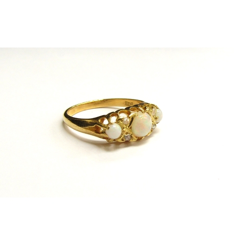 9295 - A gold ring set with three circular opals spaced by two old cut diamonds, stamped 18ct. Size L, 3g