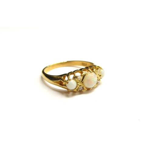 9295 - A gold ring set with three circular opals spaced by two old cut diamonds, stamped 18ct. Size L, 3g