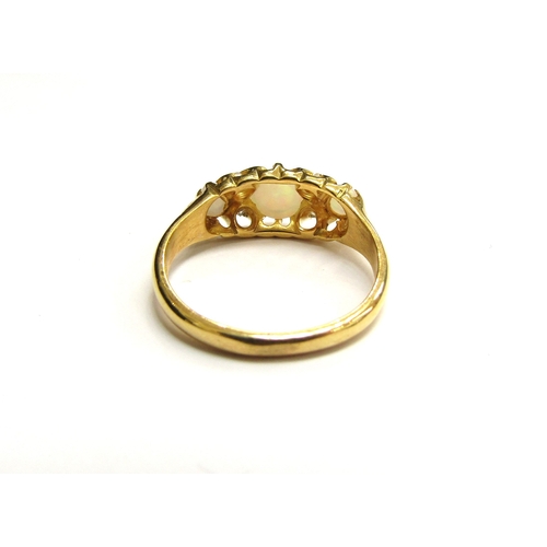 9295 - A gold ring set with three circular opals spaced by two old cut diamonds, stamped 18ct. Size L, 3g