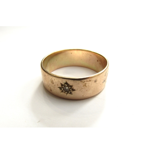 9382 - An unmarked gold band set with a small single diamond. Size  W, 5.8g