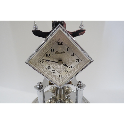 8039 - A silver coloured Olympiad anniversary clock under glass dome.  31cm tall   (E) £25-30