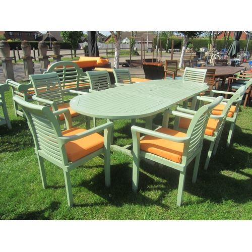 3623 - A green painted extending hardwood garden table with eight chairs and cushions