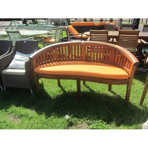 3627 - A curved teak garden bench with cushion