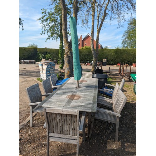 3641 - a teak garden table with eight chairs and a parasol. Two chairs need repair work      (R) £150