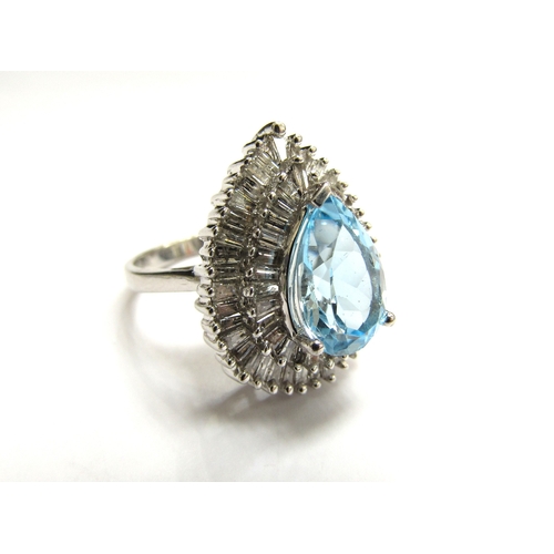 9027 - A 9ct white gold  diamond and topaz cluster ring the central pear shaped blue topaz framed with two ... 