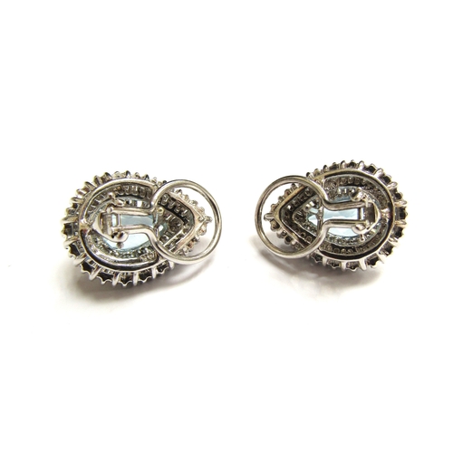 9028 - A pair of diamond and topaz cluster earrings the pear cut blue topaz framed by two rows of baguette ... 