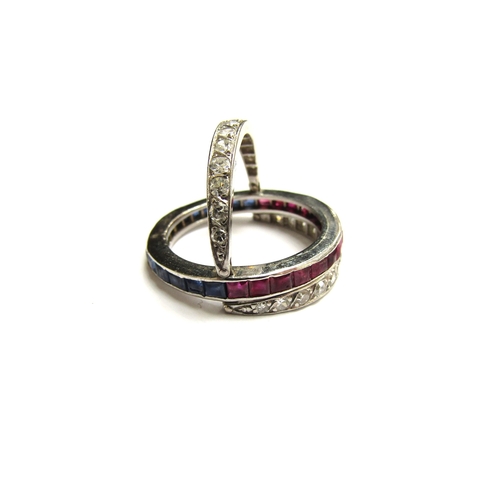 9034 - A white metal night and day ring, with half band of rubies and half band of sapphires with two hinge... 