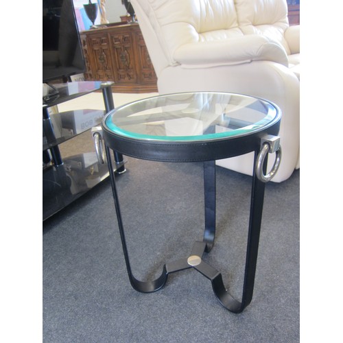 1063 - A black metal and faux leather occasional table with circular bevel edged glass top, 56cm tall x 42c... 