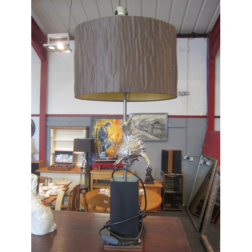 1072 - A table lamp base as a silvered shell on black plinth, brown shade, 76cm tall  (E)  £20-30