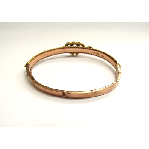 9025 - A Victorian 9ct gold bangle with linked seed pearl and turquoise set hearts, dented, 7.5g