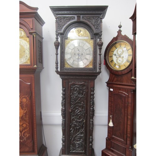 8012 - An 18th Century heavily carved oak longcase clock with silvered Roman chapter ring, date and seconds... 