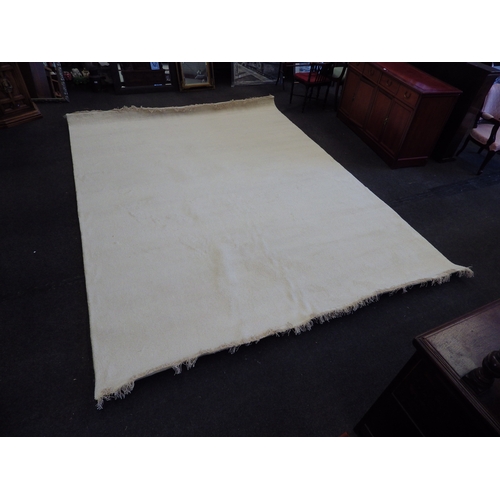 1496 - An Indian hand-knotted cream wool rug with tasselled ends, 12.1m x 9.0m