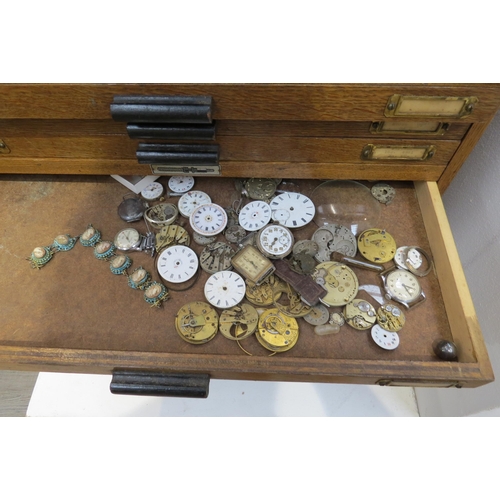 8253 - An oak 20 drawer watch makers cabinet with contents mainly 20th swiss watch parts boxed and labelled... 