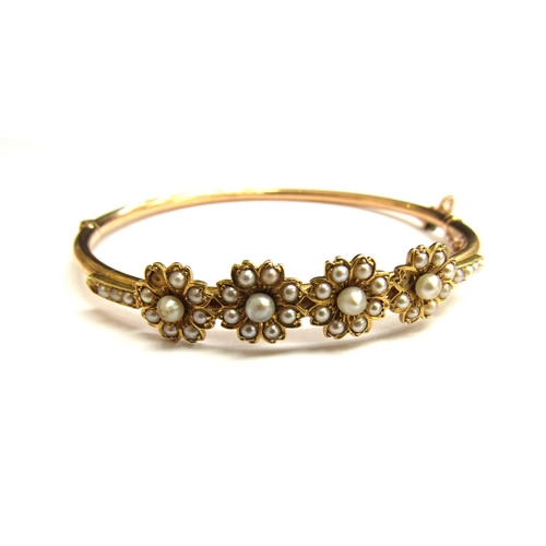 9023 - A Victorian gold hinged bangle with four flowers set with split pearls (three missing) unmarked, 6cm... 