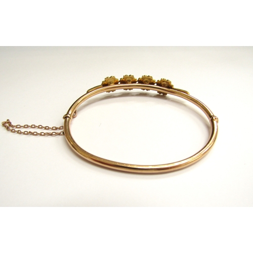 9023 - A Victorian gold hinged bangle with four flowers set with split pearls (three missing) unmarked, 6cm... 