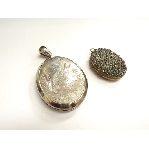 9033 - A Victorian silver oval double photograph locket with image of a stork in rushes to one side and fol... 