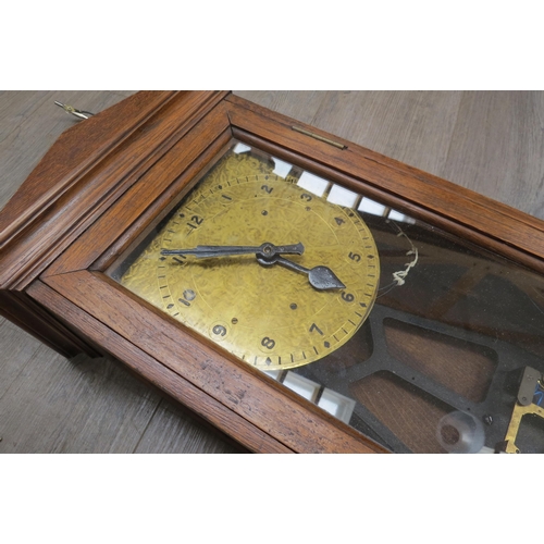 8019 - An oak cased wall hanging electric master clock with a double glass paned door, Arabic numeral dial ... 