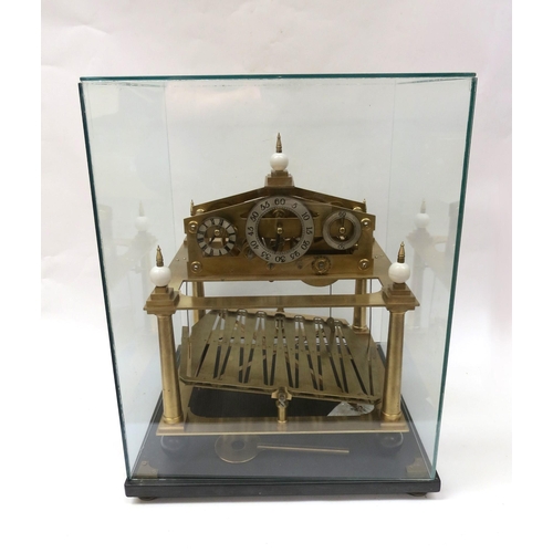 8063 - A Congreve Clock under glass case on stand with key, two steel balls and a single volume 