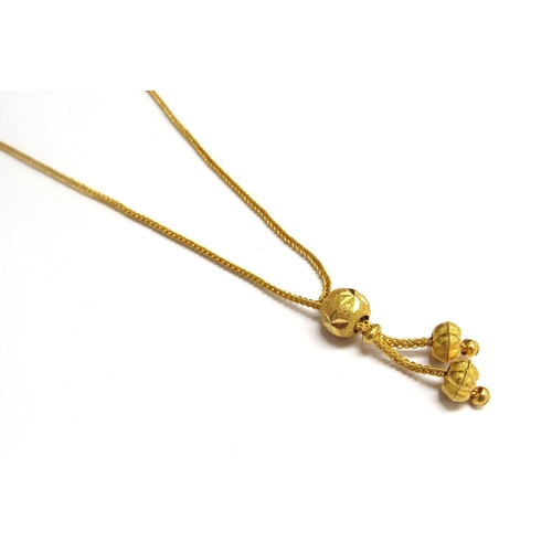 9072 - A gold necklace with slider bead and tassel ends, stamped 96.5%, 19cm long, 7.5g