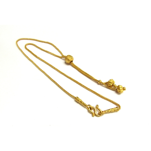 9072 - A gold necklace with slider bead and tassel ends, stamped 96.5%, 19cm long, 7.5g