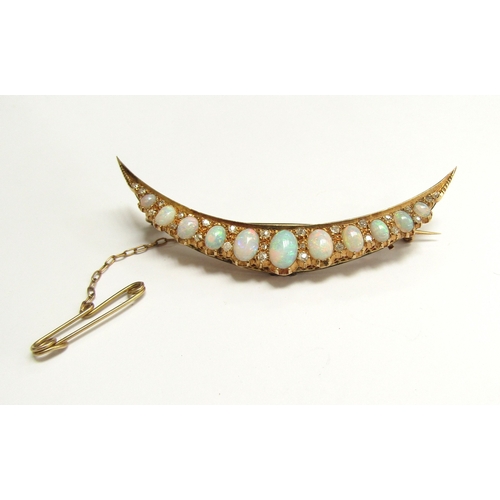 9008 - A crescent brooch set with eleven graduated opals spaced by old cut diamonds, stamped 8 and 9c, 7cm ... 