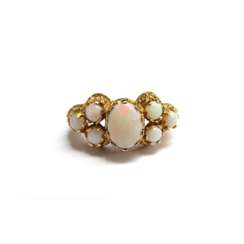 9006 - A 9ct gold ring set with seven opals. Size M, 3.7g