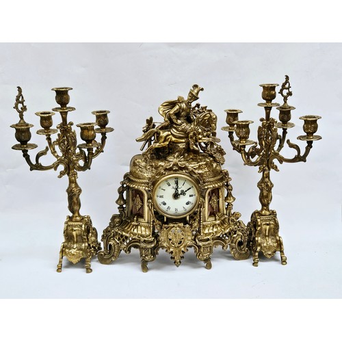 8062 - A 20th Century 'Imperial' brass clock garniture, the clock surmounted by a horseman, flanked by a pa... 