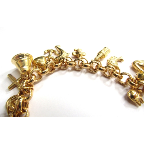 9200 - A 9ct gold charm bracelet with various hollow gold charms including, dolphin, cat, heart, bell etc, ... 