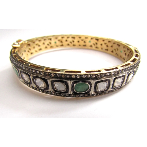 9001 - An Indian bangle with irregular shaped diamonds and emeralds outlined in black with old cut diamond ... 