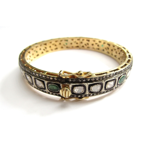 9001 - An Indian bangle with irregular shaped diamonds and emeralds outlined in black with old cut diamond ... 