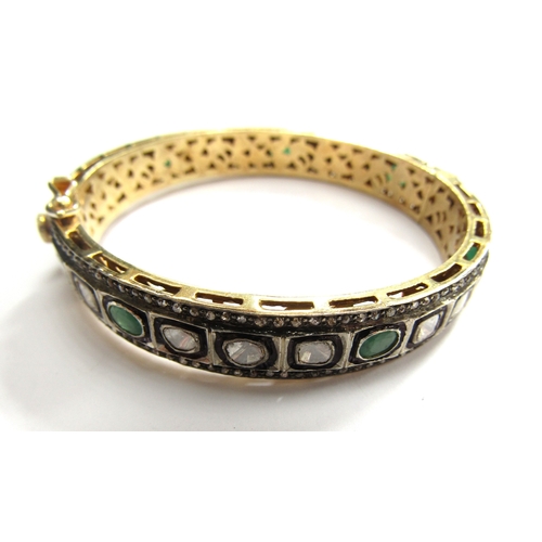 9001 - An Indian bangle with irregular shaped diamonds and emeralds outlined in black with old cut diamond ... 