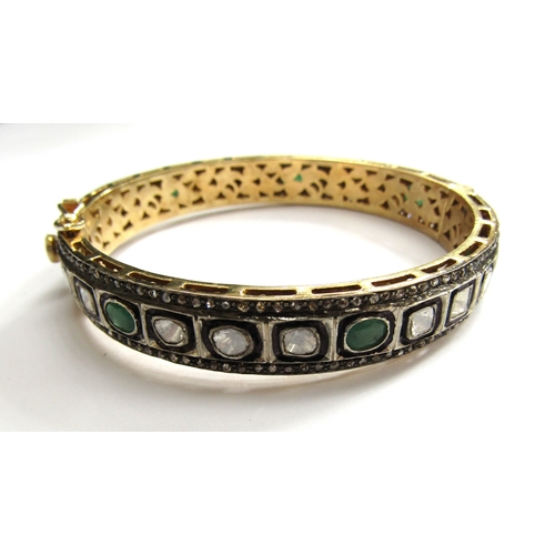 9001 - An Indian bangle with irregular shaped diamonds and emeralds outlined in black with old cut diamond ... 