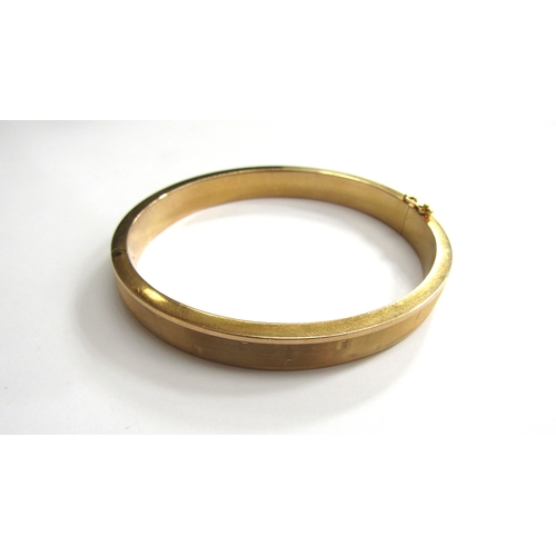 9064 - A 9ct gold hinged bangle with line design, 6.4cm x 5.7cm, 17.8g