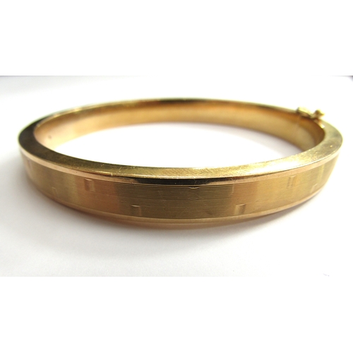 9064 - A 9ct gold hinged bangle with line design, 6.4cm x 5.7cm, 17.8g