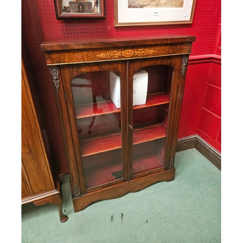 4114 - A Victorian inlaid walnut pier cabinet/bookcase with brass ormolu mounts, the two arched doors with ... 