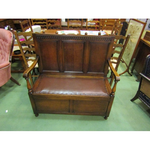 4173 - An Edwardian panelled oak box seat settle with carved decoration over a hinged seat and baluster tur... 