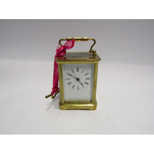 4332 - A brass cased carriage clock with key.  Bevelled glass side and door panels