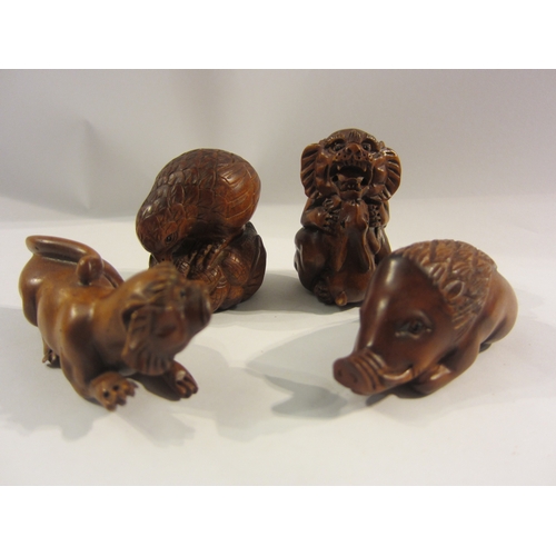 4324 - Four boxwood netsuke - bird, boar, lion, lion with rabbit, three signed