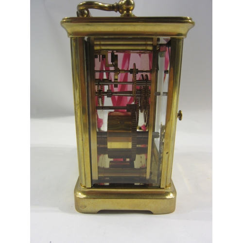 4332 - A brass cased carriage clock with key.  Bevelled glass side and door panels