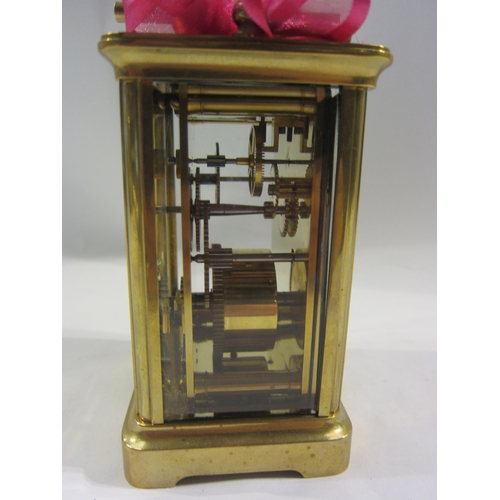 4332 - A brass cased carriage clock with key.  Bevelled glass side and door panels