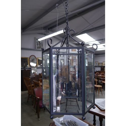 2264 - A wrought iron and bevelled glass hanging lantern with chain    (R)  £100