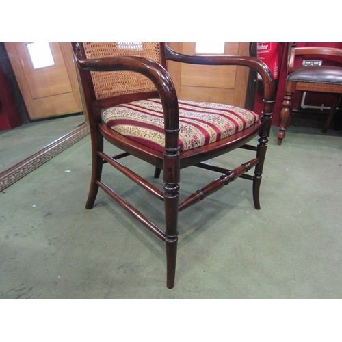 4015 - A late Victorian mahogany armchair, the caned back rest with bentwood armrests over ring turned outs... 