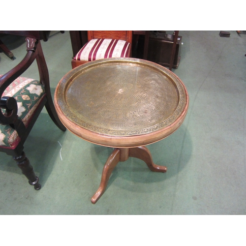 4074 - A French fruitwood circular top occasional table, the ornate brass recessed top over a turned column... 