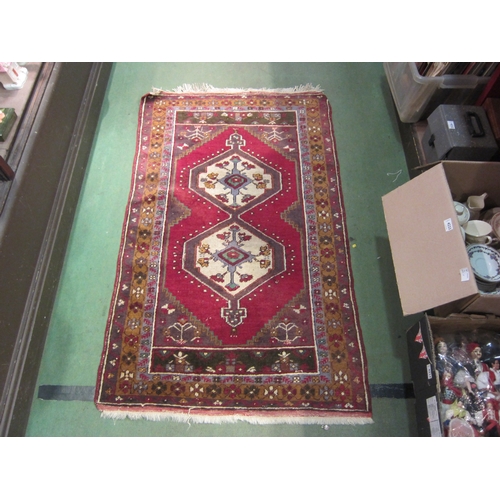 4183 - A hand woven Turkish wool rug, red ground with multiple borders and tasselled ends, 145cm x 89cm