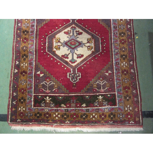 4183 - A hand woven Turkish wool rug, red ground with multiple borders and tasselled ends, 145cm x 89cm