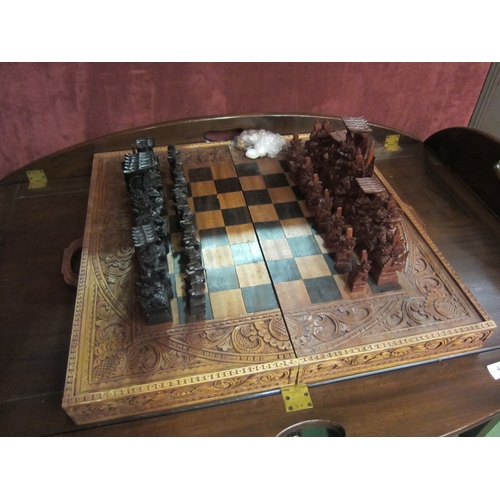 4187 - A Balinese heavily carved chess/backgammon set with tribal style carved bespoke pieces